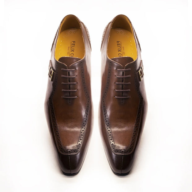 Pair of brown dress shoes with black soles on a white background