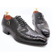 Pair of black textured dress shoes on a white background
