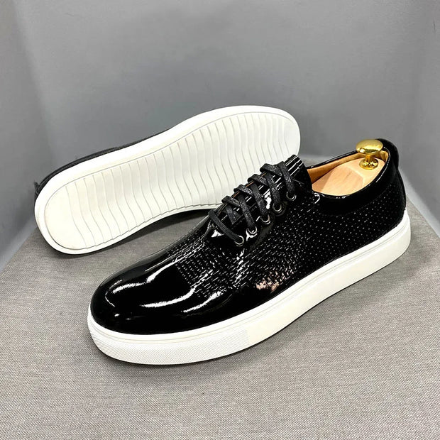 Black shiny shoes with white soles on a gray background