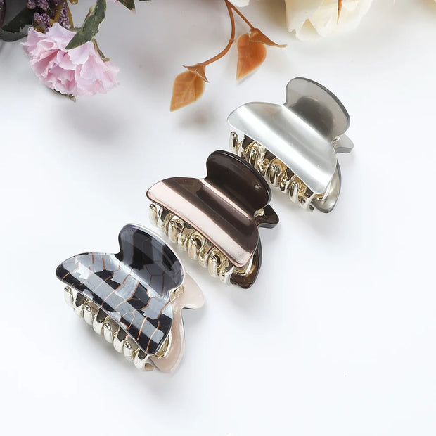 Three decorative hair clips on a white surface with floral elements.