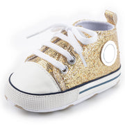 Gold glitter sneaker with white laces on a white background
