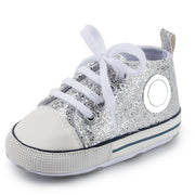 Silver glitter sneaker with white laces on a white background