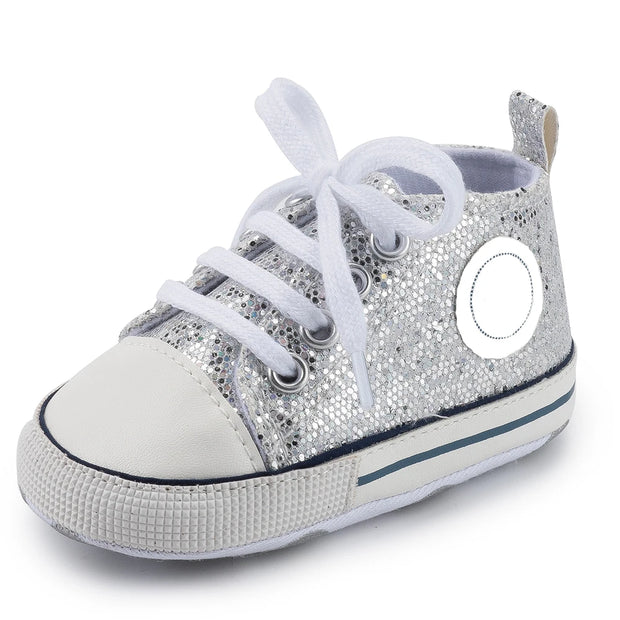 Silver glitter sneaker with white laces on a white background