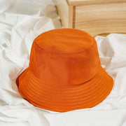 Orange bucket hat on a white fabric background