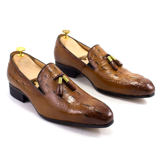 Pair of brown leather loafers with tassels on a white background