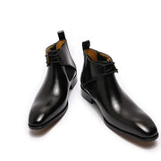 Pair of black leather boots on a white background