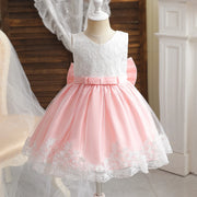 Pink and white lace dress on a mannequin against a neutral background