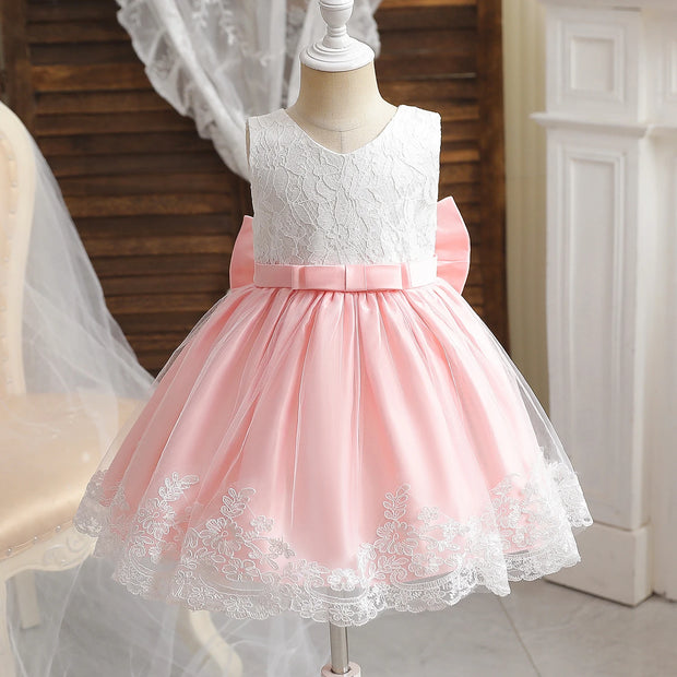 Pink and white lace dress on a mannequin against a neutral background