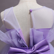 Mannequin wearing a lavender dress with a large bow detail on a plain background