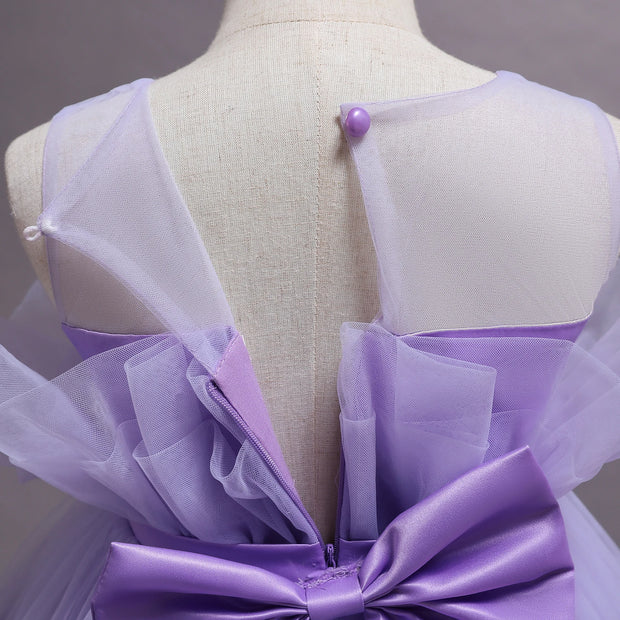 Mannequin wearing a lavender dress with a large bow detail on a plain background