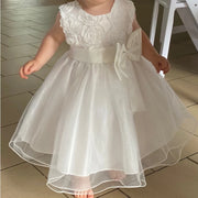 White floral dress with a large bow on a tiled floor