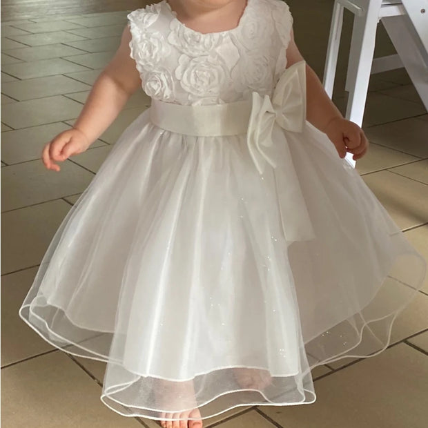 White floral dress with a large bow on a tiled floor