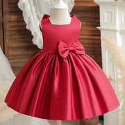 Red dress with a large bow on a mannequin against a neutral background