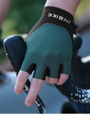 Green cycling glove with black fingertips held by a person on a blurred background