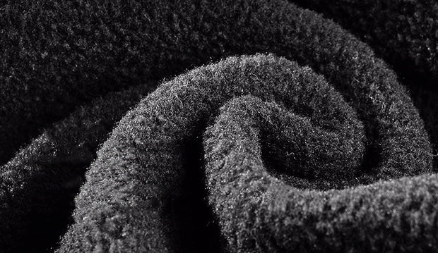Close-up of a rolled-up black carpet with textured surface