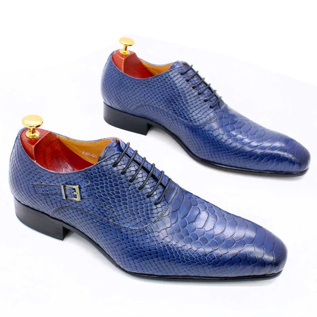 Pair of blue textured dress shoes on a white background