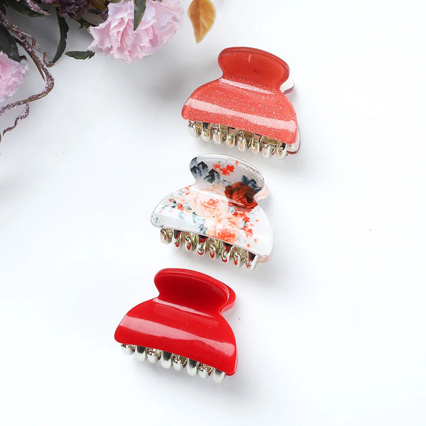 Three colorful hair clips on a white background with flowers.