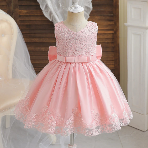 Pink lace dress on a mannequin with a wooden background