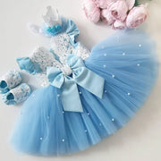 Blue baby dress with bow, shoes, and headband on a light background