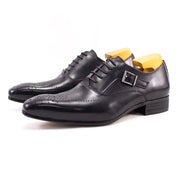Black leather dress shoes with a buckle on a white background