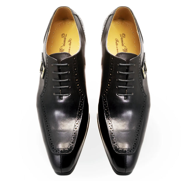 Pair of black dress shoes with brand name on a white background
