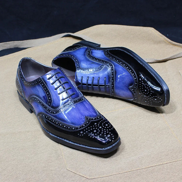Blue and black dress shoes on a beige surface