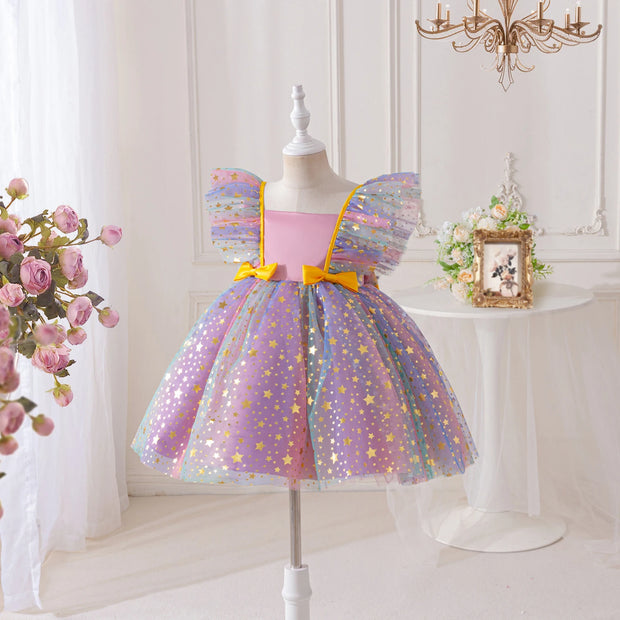 Children's dress with star pattern on a mannequin against a white wall.