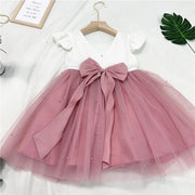 Pink dress with a large bow on a white background