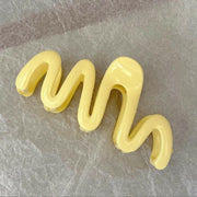 Yellow silicone mold shaped like a snake on a gray surface