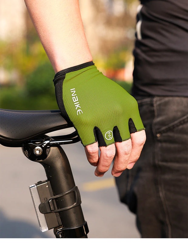 Green cycling glove on a person's hand with a blurred background