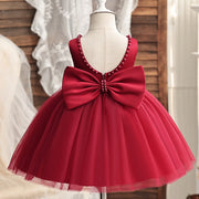 Red dress with a large bow on a mannequin against a neutral background