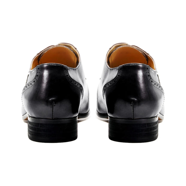 Black dress shoes with brown soles on a white background