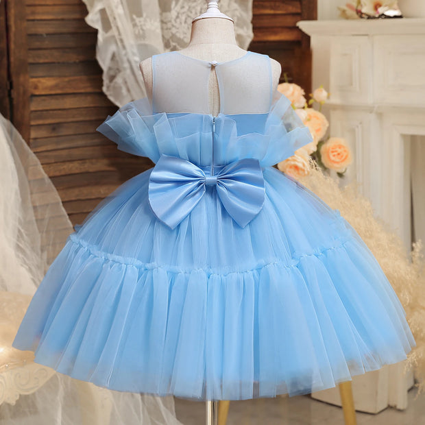 Light blue dress with a large bow on a mannequin against a decorative background.