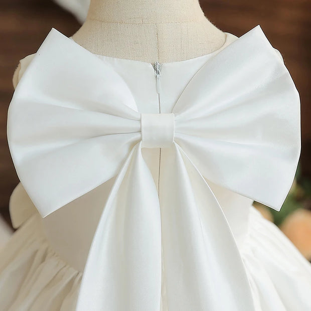 White dress with a large bow on a mannequin against a blurred background
