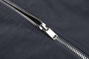 Close-up of a silver zipper on a dark fabric background