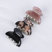 Set of four hair clips in black, tortoiseshell, and rose gold on a white background