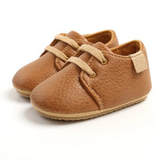 Pair of brown baby shoes with soft sole on a white background