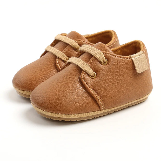 Pair of brown baby shoes with soft sole on a white background