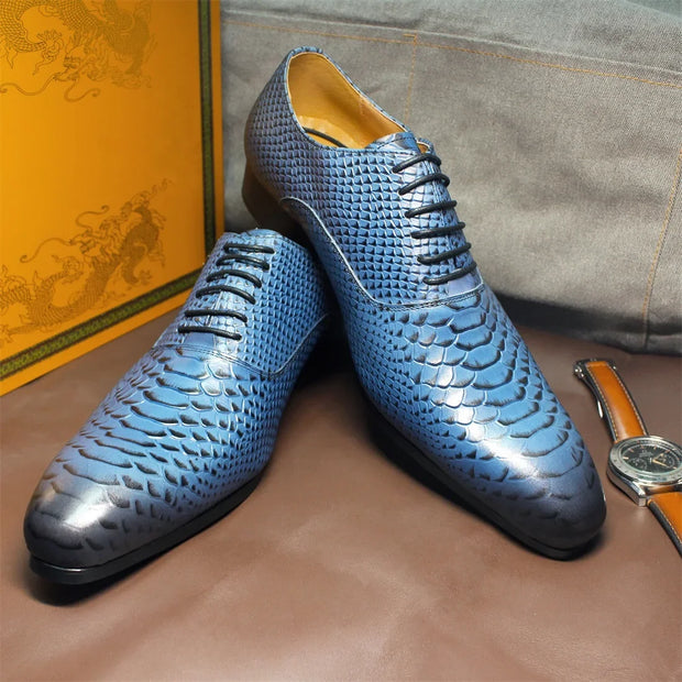 Blue patterned shoes on a brown surface with a watch and box in the background