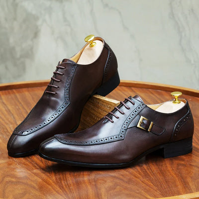 Pair of brown leather dress shoes on a wooden surface with a neutral background