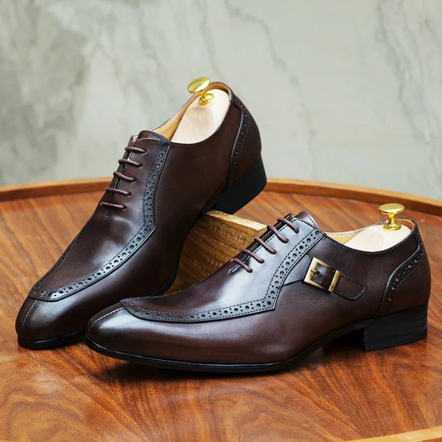 Pair of brown leather dress shoes on a wooden surface with a neutral background