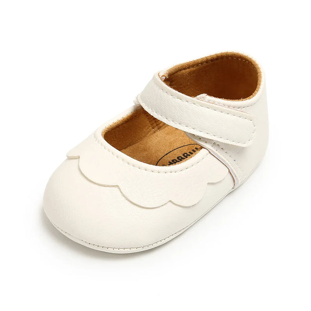 White baby shoe with a scalloped edge on a white background