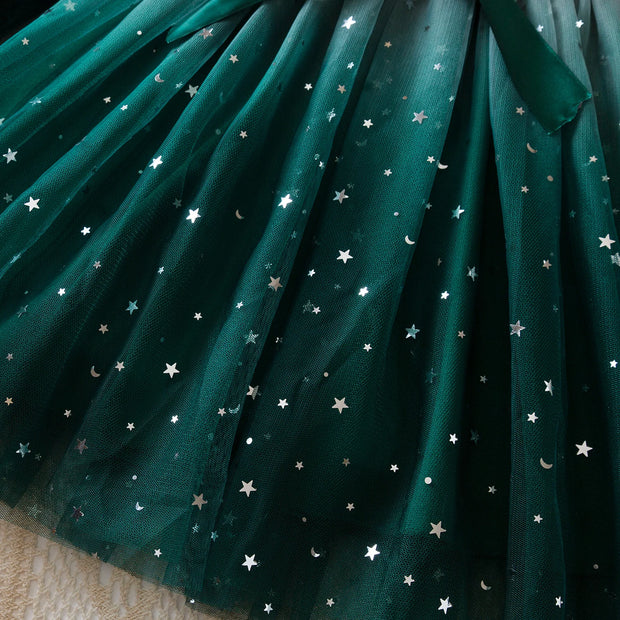 Green fabric with star and moon patterns on a textured surface
