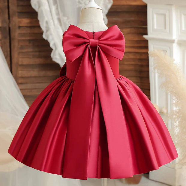 Red dress with a large bow on a mannequin against a neutral background