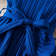 Close-up of a blue dress with a tie detail on a textured surface