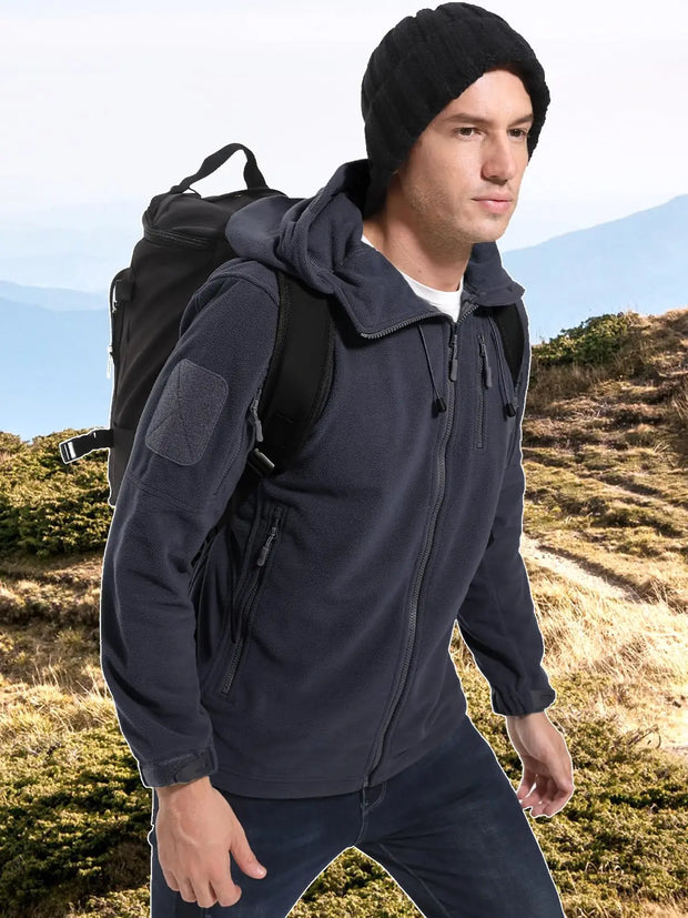 Man wearing a dark jacket and black beanie with a backpack on a mountain trail