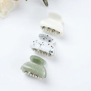 Three hair clips with different designs on a white background