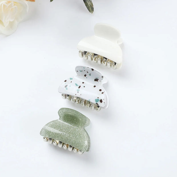 Three hair clips with different designs on a white background