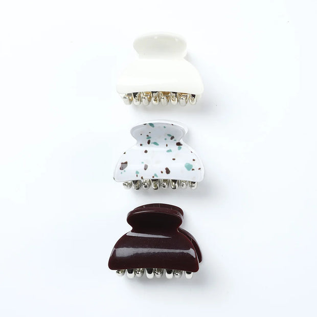 Set of three hair clips with different designs on a white background