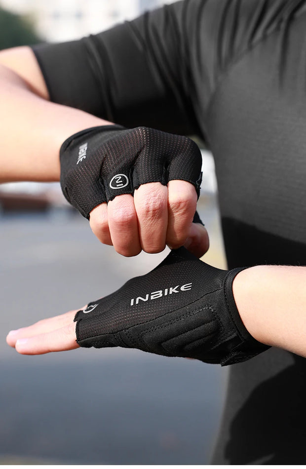 Person wearing black gloves holding hands together.